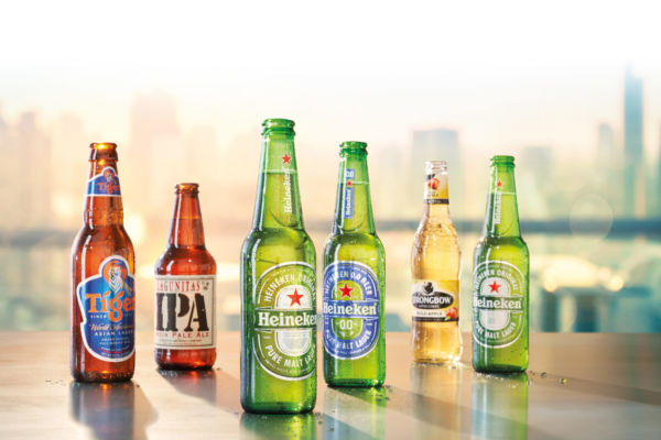 Bottiglie di birra Heineken e altre marche. Investimento Bill Gates in Heineken.