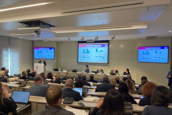 Conferenza FIPE: presentazione rapporto ristorazione. Relatore al podio, grafici proiettati. Pubblico attento.