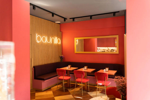 Interni della pasticceria Baunilla Brera San Marco. Arredamento colorato, insegna al neon e sedute accoglienti.