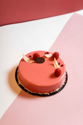 Torta Baunilla Brera: dessert rosa con lamponi e decorazioni bianche. Pasticceria artigianale italiana.