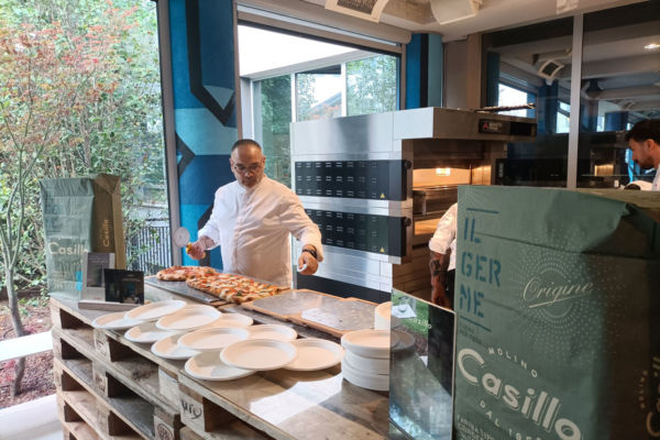Chef taglia pizza DAC con farina Casillo. Forno per pizza sullo sfondo. #pizza #dac #casillo #food