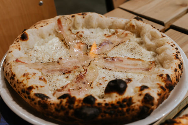 Pizza alla Gricia in fiamme, Mercato Centrale Torino. Specialità food con guanciale croccante.