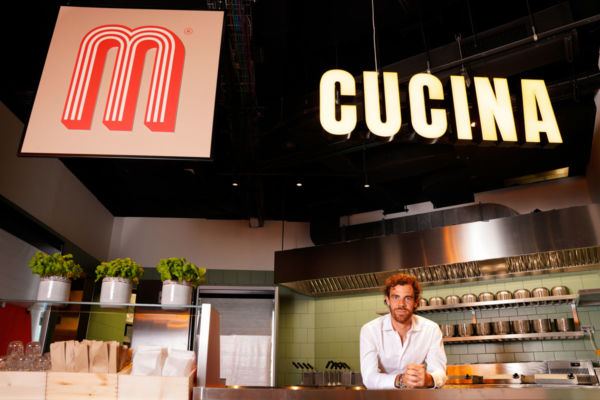 Alberto Cartasegna di Miscusi nel ristorante. Logo Miscusi, insegna Cucina, basilico.