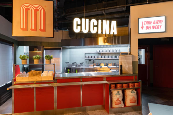 Cucina Miscusi: ambiente con bancone rosso, logo M, scritta Cucina e indicazione Take Away Delivery.
