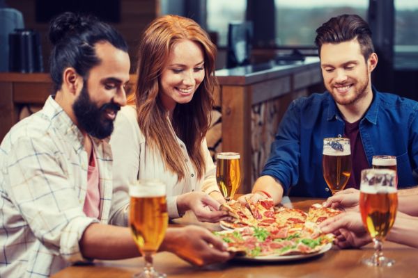 Amici con pizza e birra artigianale. Volano per l'agroalimentare italiano.