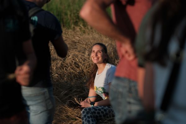 Donna sorridente seduta nel campo di grano per Adotta un Raccolto di Farina Petra. Edizione 2023.