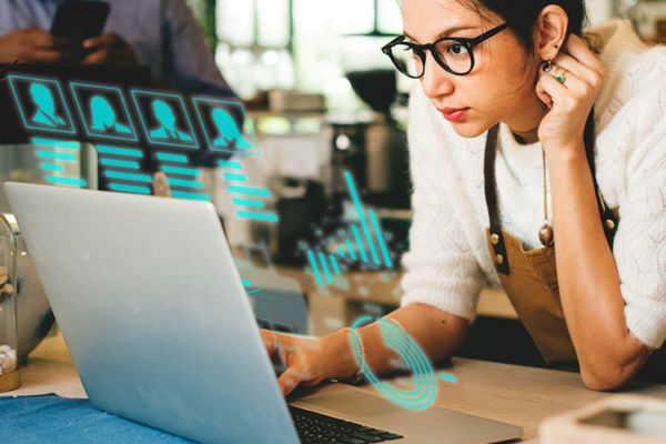 AI per ristorazione: donna al laptop con grafici. Vantaggi intelligenza artificiale per ristoranti.