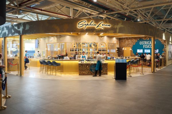 Autogrill Fiumicino: Ristorante Sophia Loren, food court. Design elegante, bancone bar dorato e sedute.
