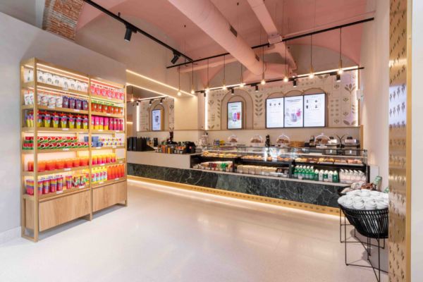 Interni Starbucks Cerretani Firenze: bancone bar, scaffale merchandising colorato. Design moderno e accogliente.