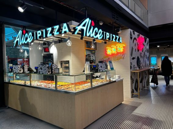 Pizzeria Alice Pizza Chef Express. Vetrina con pizza al taglio, insegna luminosa.