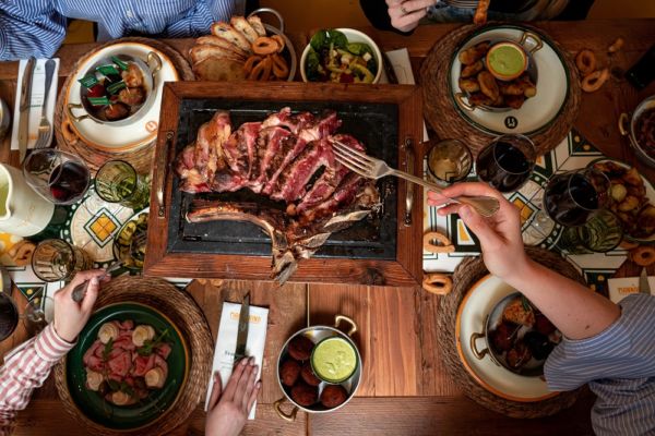 Tavola imbandita Il Mannarino: tagliata di carne, contorni e vino. Esperienza culinaria, ristorante Il Mannarino.