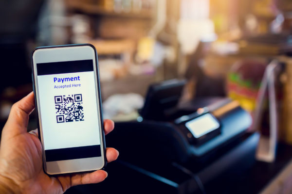 Pagamento digitale: smartphone con QR code per food delivery e consumi.