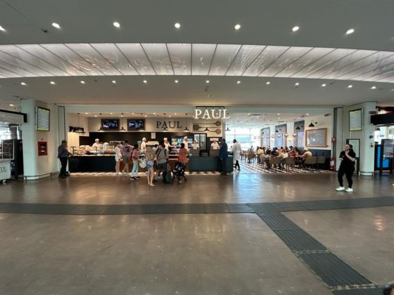 Nuova panetteria PAUL a Roma Termini. Persone in fila al bancone e sedute ai tavoli.