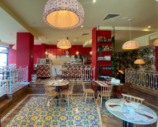 Interni del ristorante Pizzium a Bolzano. Arredamento colorato, tavoli apparecchiati e atmosfera accogliente.