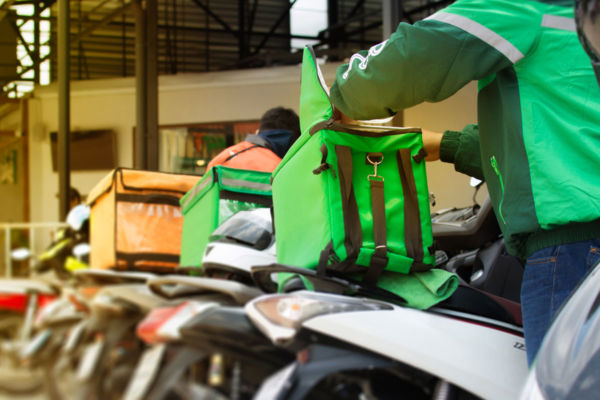 Riders delivery con scooter e zaini termici. Piattaforme delivery cibo.