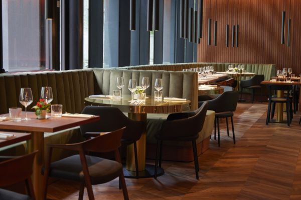 Interni del ristorante Cocciuto Turati a Milano. Tavoli apparecchiati, sedie di design e divanetti.