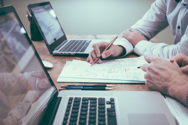 Associazioni franchising: persone che collaborano con laptop e documenti.