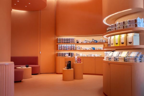 Interni Incantalia Trieste: negozio di prodotti alimentari, scaffali con tè e specialità. Design color pesca.