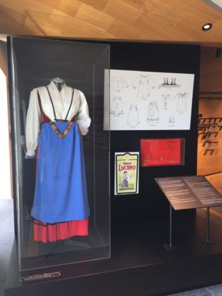 Mostra Amaro Lucano: costume tradizionale lucano in vetrina e cartellone pubblicitario vintage.