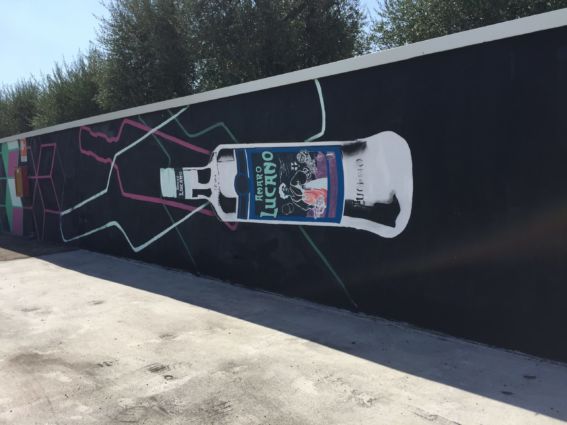 Murales Amaro Lucano: arte urbana con bottiglia stilizzata. Lucano a Singapore.
