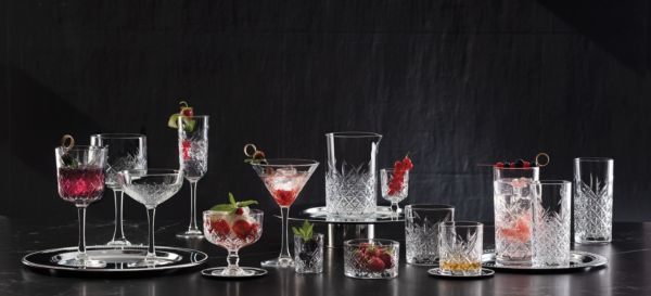 Collezione Timeless Impilabile: bicchieri da cocktail in cristallo con decori geometrici e bevande colorate.