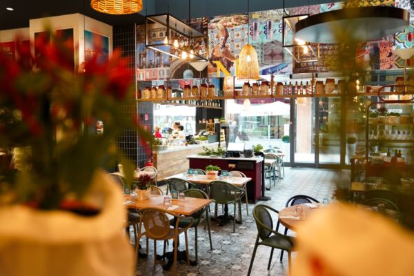 Interno del ristorante Rossopomodoro Autogrill a Vicolungo Outlet con tavoli e decorazioni.
