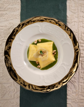Divine Creazioni Surgital: bauletti ripieni porcini e taleggio su piatto elegante. Pasta fresca ripiena di alta qualità.
