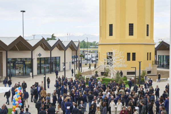 Nhood: apertura nuovo centro commerciale. Persone, torre gialla e negozi. Evento Nhood, terzo trimestre 2023.