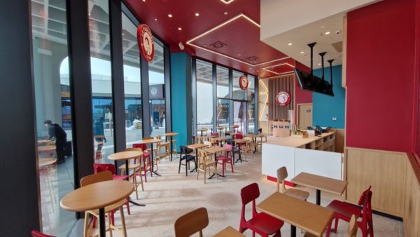 Interno de La Piadineria: tavoli, sedie e vetrate ampie. Ristorante accogliente e luminoso.